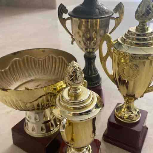 مجموعه كؤوس للمسابقات الرياضيه.   اللون زهبي.  بقاعده بلاستيك خشبي 